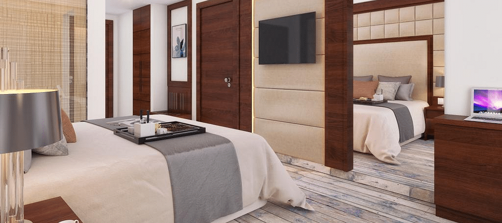 A cozy room with a king-size bed, wall-mounted television, and warm lighting at BluSalzz Residence, Amritsar.